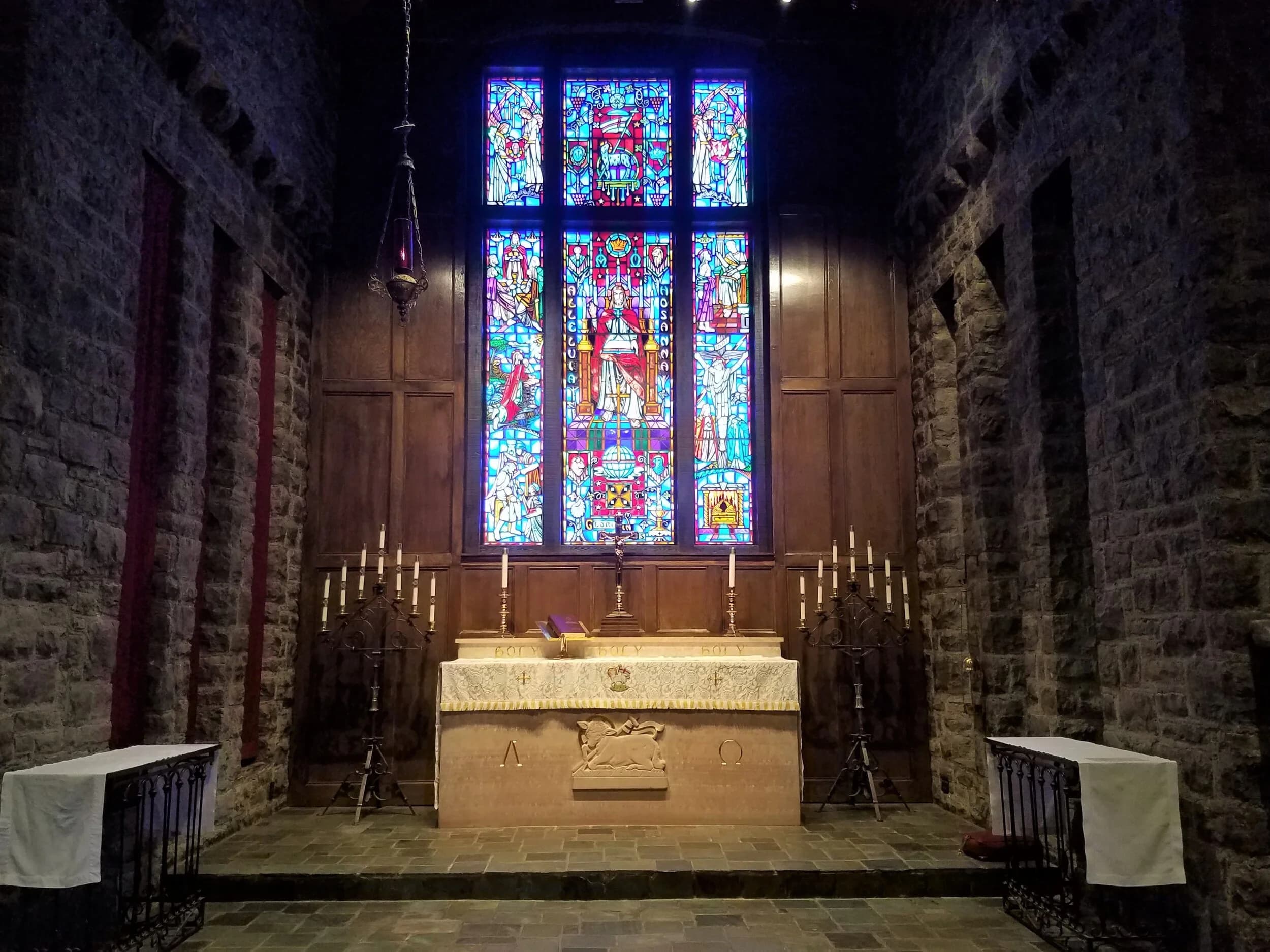 The candlelit chancel and stained-glass reredos at Grace Evangelical Lutheran Church